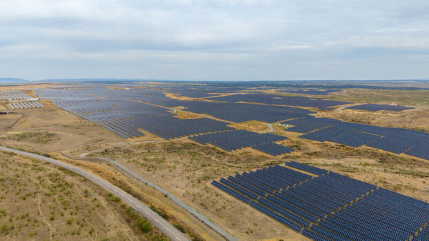 Aerial view of a large solar farm with rows of photovoltaic panels stretching across the dry landscape near a road in Talavan Extremadura Spain. Aerial view of a large solar farm with rows of photovoltaic panels stretching across the dry landscape near a road in Talavan Extremadura Spain.