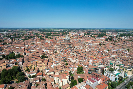 Aerial view of the historic center of Pavia featuring the majestic Duomo di Pavia dome and red tiled rooftops under a clear blue sky in Pavia Lombardy Italy. Aerial view of the historic center of Pavia featuring the majestic Duomo di Pavia dome and red tiled rooftops under a clear blue sky in Pavia Lombardy Italy.
