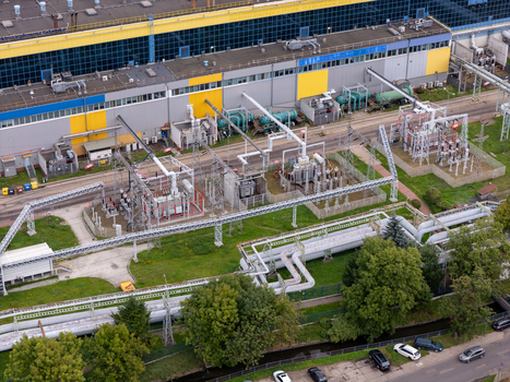 Aerial view of the coal fired power plant featuring industrial pipelines electrical transformers and a large building with yellow and blue panels in Gdansk Poland. Aerial view of the coal fired power plant featuring industrial pipelines electrical transformers and a large building with yellow and blue panels in Gdansk Poland.