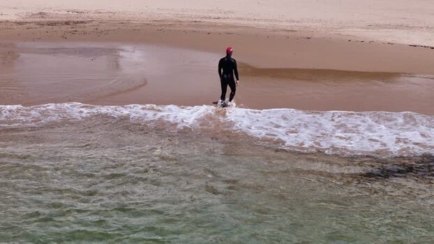 Aerial view of a swimmer walking into the ocean Portugal.