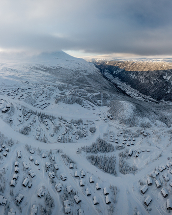Aerial view of Gaustablikk Fjellresort featuring numerous wooden cabins nestled in a vast snowy mountain landscape with ski slopes in Rjukan Telemark Norway. Aerial view of Gaustablikk Fjellresort featuring numerous wooden cabins nestled in a vast snowy mountain landscape with ski slopes in Rjukan Telemark Norway.