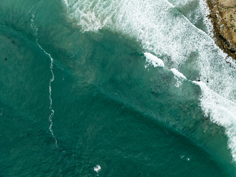 Aerial view of La Jolla Cove with turquoise waves crashing against the rocky shoreline and white sea foam in San Diego California United States. Aerial view of La Jolla Cove with turquoise waves crashing against the rocky shoreline and white sea foam in San Diego California United States.