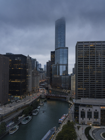 Chicago United States 15 September 2025 View of the Chicago River and Trump International Hotel and Tower shrouded in low clouds and fog with city skyscrapers and boats.
