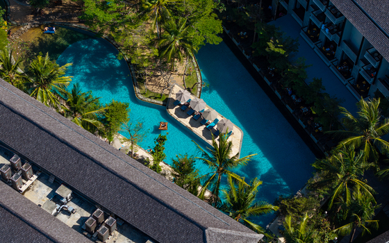 Aerial view of Marriott s Bali Nusa Dua Gardens featuring a turquoise swimming pool with lounge chairs on a small island surrounded by palm trees in Kecamatan Kuta Selatan Bali Indonesia.