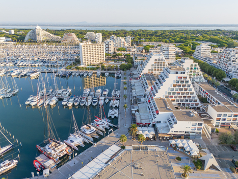 Aerial view of the marina filled with yachts and distinctive pyramid shaped architecture along the waterfront in La Grande Motte Occitanie France.