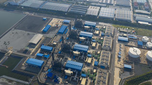 Aerial view of the Gulf Pluak Daeng Power Plant industrial complex with blue roofed buildings and tall chimneys in Map Yang Phon Rayong Thailand. Aerial view of the Gulf Pluak Daeng Power Plant industrial complex with blue roofed buildings and tall chimneys in Map Yang Phon Rayong Thailand.