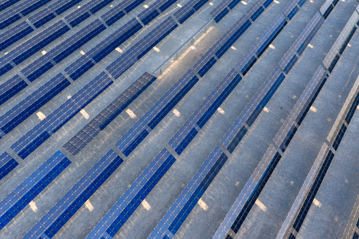 Aerial view of rows of blue solar panels installed on a desert landscape under bright sunlight Enterprise Nevada United States. Aerial view of rows of blue solar panels installed on a desert landscape under bright sunlight Enterprise Nevada United States.