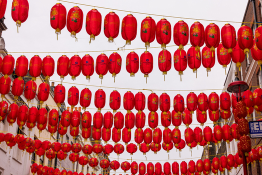 London United Kingdom 12 May 2025 View of red Chinese lanterns hanging in rows across a street in Chinatown under an overcast sky.