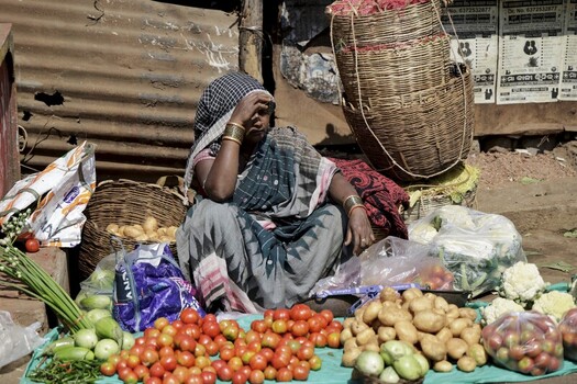 Odisha India 26 March 2026 View of a woman amidst vibrant produce a tapestry of textures and colors selling tomatoes cauliflower and potatoes. Odisha India 26 March 2026 View of a woman amidst vibrant produce a tapestry of textures and colors selling tomatoes cauliflower and potatoes.