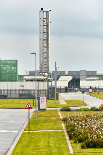 Middenmeer Netherlands 17 May 2026 View of the Microsoft datacenter facility on Agriport featuring tall industrial exhaust stacks and green landscaping under an overcast sky.