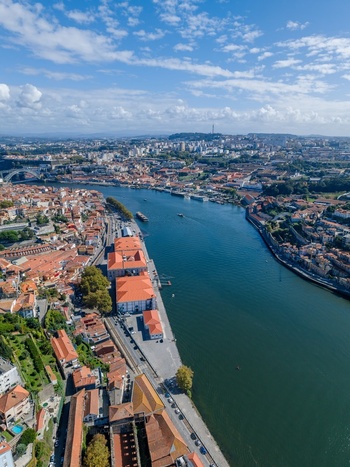 Aerial view of the historic city of Porto along the Douro River featuring terracotta rooftops traditional architecture and urban infrastructure in Porto Porto District Portugal.