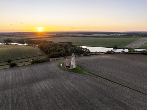 Aerial view of the historic Pusztatorony ruins surrounded by agricultural fields and a pond at sunset in Somogyvamos Hungary. Aerial view of the historic Pusztatorony ruins surrounded by agricultural fields and a pond at sunset in Somogyvamos Hungary.