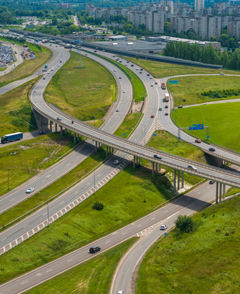 Aerial view of a complex highway interchange with multiple lanes vehicles and green surroundings in Kaunas Kaunas County Lithuania.
