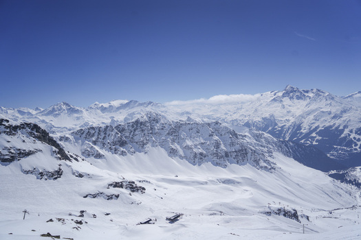 Aerial view of the snow covered peaks and ski slopes of La Rosiere resort under a clear blue sky in the French Alps at Montvalezan Auvergne Rhone Alpes France.