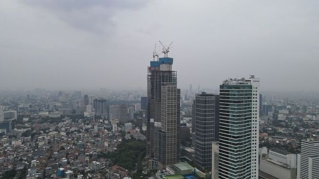 Aerial view of skyscrapers and urban development in Jakarta Pusat featuring a building under construction with cranes in Kecamatan Menteng Daerah Khusus Ibukota Indonesia. Aerial view of skyscrapers and urban development in Jakarta Pusat featuring a building under construction with cranes in Kecamatan Menteng Daerah Khusus Ibukota Indonesia.