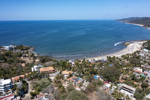 Aerial view of Sayulita beach with lush palm trees coastal buildings and turquoise ocean waters in Sayulita Nayarit Mexico. Aerial view of Sayulita beach with lush palm trees coastal buildings and turquoise ocean waters in Sayulita Nayarit Mexico.