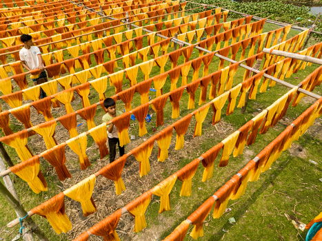 Narayanganj Bangladesh 30 March 2026 Aerial view of vibrant sun drenched textiles suspended in neat rows creating a striking pattern of color and texture.