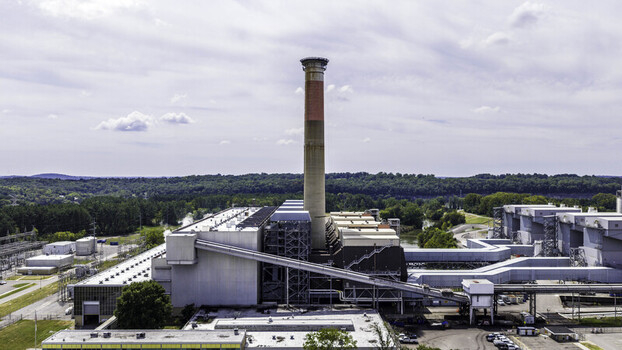Aerial view of the Gallatin Fossil Plant coal fired power station featuring a prominent exhaust stack and industrial infrastructure surrounded by lush greenery in Gallatin TN United States.