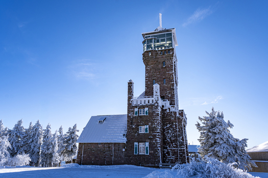 View of a snow dusted tower reaching into the bright blue sky surrounded by frosted trees in the crisp winter air Sasbach Baden Württemberg Germany. View of a snow dusted tower reaching into the bright blue sky surrounded by frosted trees in the crisp winter air Sasbach Baden Württemberg Germany.
