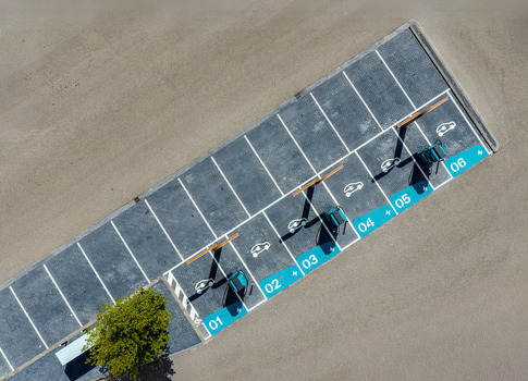 Aerial view of an electric vehicle charging station with numbered parking spots in a paved lot in Beilen Drenthe Netherlands.