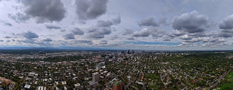 Aerial view of the Denver skyline and the Cherry Creek area with residential neighborhoods lush trees and a cloudy sky in Denver Colorado United States. Aerial view of the Denver skyline and the Cherry Creek area with residential neighborhoods lush trees and a cloudy sky in Denver Colorado United States.