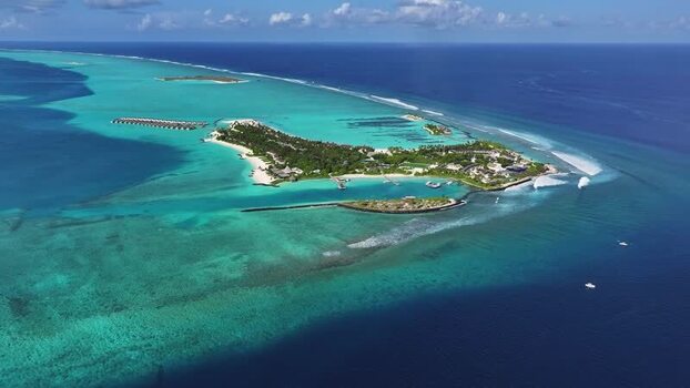 Aerial view of a resort island and turquoise lagoons Thulusdhoo Maldives.