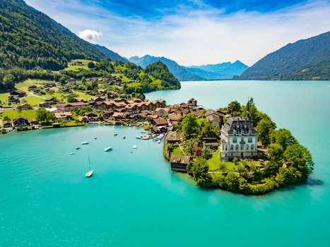 Aerial view of the turquoise waters embrace the picturesque village and the grand Chateau d Iseltwald nestled amidst lush greenery Iseltwald Canton of Bern Switzerland. Aerial view of the turquoise waters embrace the picturesque village and the grand Chateau d Iseltwald nestled amidst lush greenery Iseltwald Canton of Bern Switzerland.