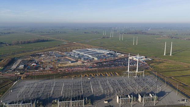 Groningen Netherlands 20 January 2026 Aerial view of Datacenter Westpoort with a large power substation construction site and wind turbines across the flat Dutch landscape.