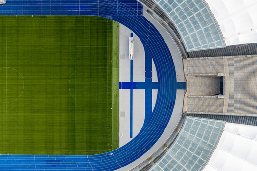 Berlin Germany 26 September 2026 Aerial view of Olympiastadion Berlin showing the vibrant green football pitch the blue running track and the modern stadium roof structure.