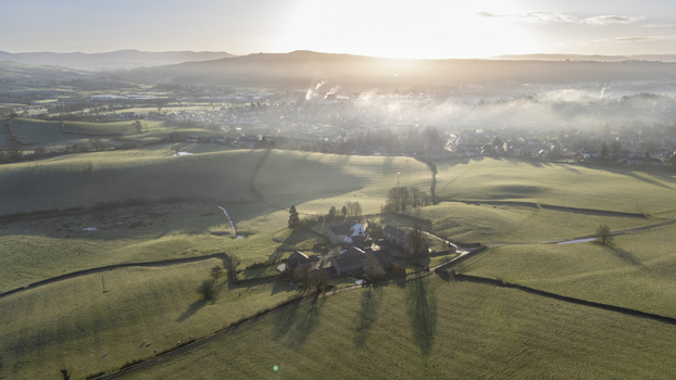 Aerial view of golden sunlight kissing the misty fields and historic buildings creating a tapestry of light and shadow Ledbury England United Kingdom. Aerial view of golden sunlight kissing the misty fields and historic buildings creating a tapestry of light and shadow Ledbury England United Kingdom.