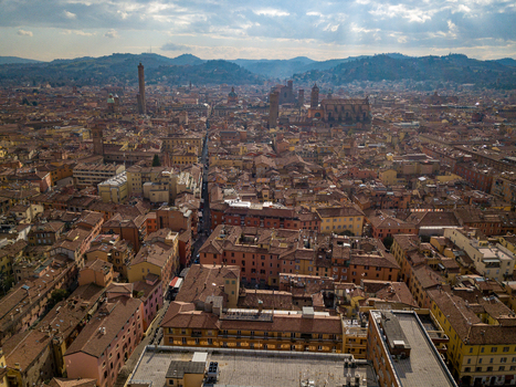 Aerial view of the historic center with red tiled rooftops and the iconic Two Towers Garisenda and Asinelli under a cloudy sky in Bologna Emilia Romagna Italy. Aerial view of the historic center with red tiled rooftops and the iconic Two Towers Garisenda and Asinelli under a cloudy sky in Bologna Emilia Romagna Italy.