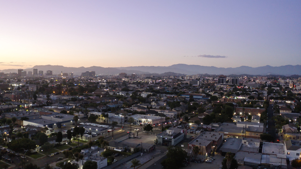 Aerial view of the sprawling Los Angeles cityscape at dusk featuring dense urban architecture distant mountains and a soft twilight sky Los Angeles California United States. Aerial view of the sprawling Los Angeles cityscape at dusk featuring dense urban architecture distant mountains and a soft twilight sky Los Angeles California United States.