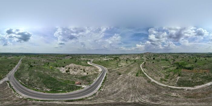 Aerial view of a winding road cutting through the rural hilly landscape of Bojonegoro East Java Indonesia. Aerial view of a winding road cutting through the rural hilly landscape of Bojonegoro East Java Indonesia.