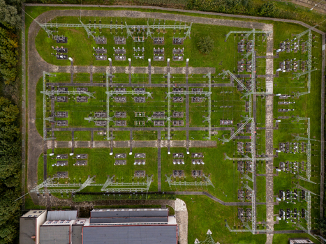 Aerial view of an electrical substation with high voltage equipment metal structures and power lines set within a green grassy area in Gdansk Poland. Aerial view of an electrical substation with high voltage equipment metal structures and power lines set within a green grassy area in Gdansk Poland.