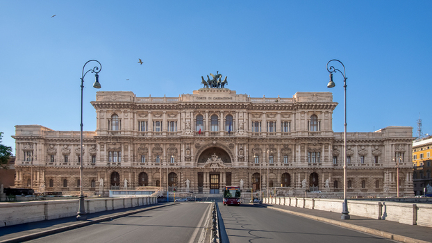 View of the grand facade of the Palazzo di Giustizia the seat of the Supreme Court of Cassation featuring ornate neoclassical architecture and a bronze quadriga in Rome Lazio Italy. View of the grand facade of the Palazzo di Giustizia the seat of the Supreme Court of Cassation featuring ornate neoclassical architecture and a bronze quadriga in Rome Lazio Italy.