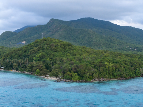 Aerial view of the lush green island meeting the turquoise sea under a cloudy sky Tanjung Gelam Beach Karimunjawa Central Java Indonesia. Aerial view of the lush green island meeting the turquoise sea under a cloudy sky Tanjung Gelam Beach Karimunjawa Central Java Indonesia.