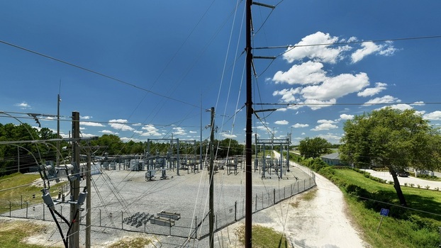 Aerial view of the Georgia Pacific Palatka Operations facility featuring electrical infrastructure power lines and greenery under a bright blue sky in Palatka Florida United States.