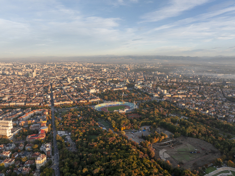 Aerial view of Vasil Levski National Stadium surrounded by lush parkland and the dense urban cityscape of Sofia under a clear sky. Sofia Sofia City Province Bulgaria. Aerial view of Vasil Levski National Stadium surrounded by lush parkland and the dense urban cityscape of Sofia under a clear sky. Sofia Sofia City Province Bulgaria.