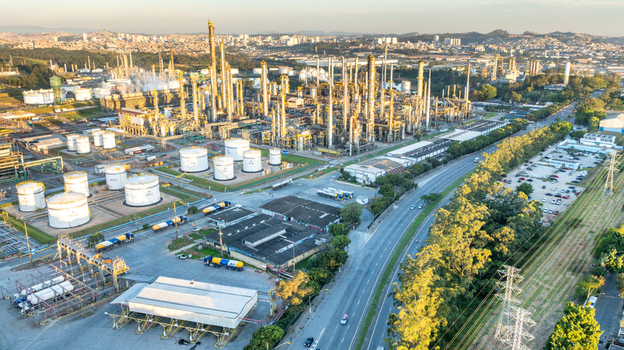 Aerial view of a large petrochemical complex with tall distillation towers and storage tanks situated near a highway in an urban industrial area in Santo Andre State of Sao Paulo Brazil.