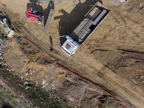 Aerial view of a construction site with a truck loaded with metal bars and a worker standing nearby on the dirt ground in Istanbul Istanbul Turkiye.