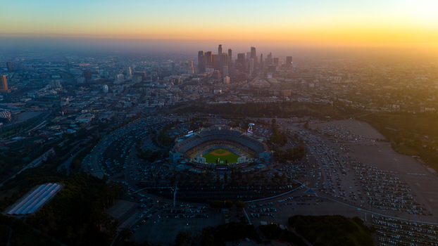 Aerial view of the vibrant Dodger Stadium nestled amidst a sea of cars under the soft glow of the setting sun Los Angeles California United States. Aerial view of the vibrant Dodger Stadium nestled amidst a sea of cars under the soft glow of the setting sun Los Angeles California United States.