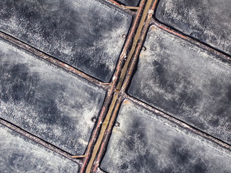 Aerial view of salt pans with textured dark surfaces and narrow channels in Vietnam. Aerial view of salt pans with textured dark surfaces and narrow channels in Vietnam.