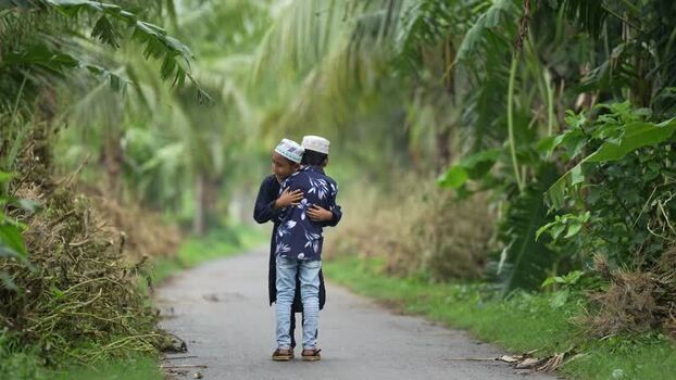 View of two young boys hugging on a rural path in Bangladesh. View of two young boys hugging on a rural path in Bangladesh.