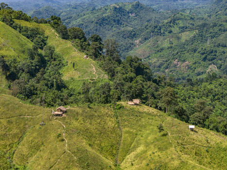 Aerial view of Shita Pahar featuring lush green hills small wooden huts on the ridges and winding dirt paths in Kaptai Chittagong Division Bangladesh. Aerial view of Shita Pahar featuring lush green hills small wooden huts on the ridges and winding dirt paths in Kaptai Chittagong Division Bangladesh.