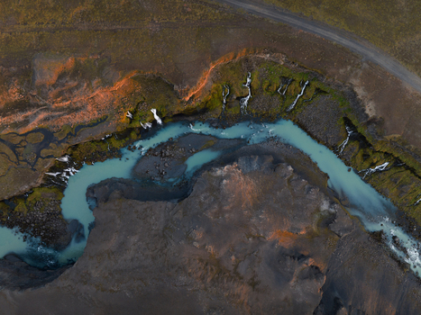 Aerial view of a turquoise river snaking through the rugged terrain where golden light kisses the verdant edges contrasting with the dark volcanic earth Sigöldugljúfur Rangárþing ytra Iceland. Aerial view of a turquoise river snaking through the rugged terrain where golden light kisses the verdant edges contrasting with the dark volcanic earth Sigöldugljúfur Rangárþing ytra Iceland.