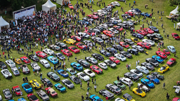 La Chapelle de Guinchay France 01 June 2024 Aerial view of a large gathering of classic and sports cars parked in rows on a green field with a crowd of people near a stage. La Chapelle de Guinchay France 01 June 2024 Aerial view of a large gathering of classic and sports cars parked in rows on a green field with a crowd of people near a stage.