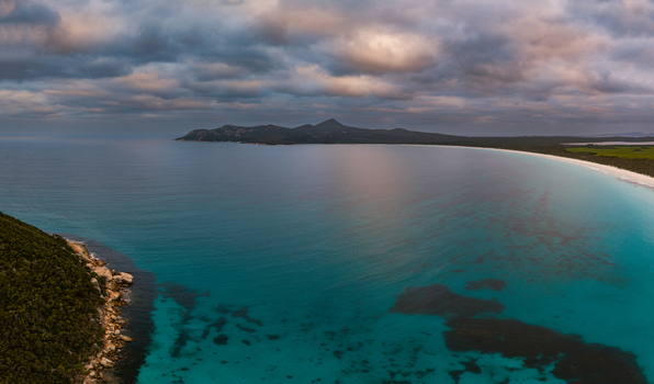 Aerial view of Bettys Beach with turquoise water rocky coastline and dramatic clouds over the horizon in Albany WA Australia. Aerial view of Bettys Beach with turquoise water rocky coastline and dramatic clouds over the horizon in Albany WA Australia.