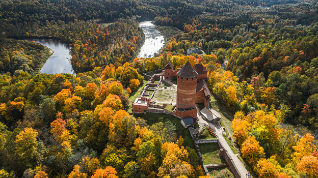 Aerial view of Turaida Castle surrounded by vibrant autumn forests and the winding Gauja River in Sigulda Sigulda Municipality Latvia. Aerial view of Turaida Castle surrounded by vibrant autumn forests and the winding Gauja River in Sigulda Sigulda Municipality Latvia.
