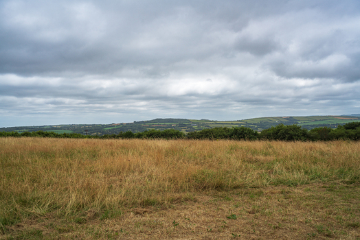 View of the rolling countryside and grassy fields under a cloudy sky in Bodmin Cornwall United Kingdom. View of the rolling countryside and grassy fields under a cloudy sky in Bodmin Cornwall United Kingdom.