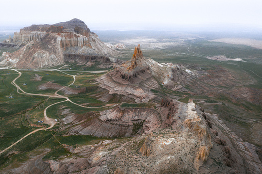 Aerial view of the dramatic Airakty rock formations and desert landscape with winding dirt roads and sparse vegetation in Shetpe Mangystau Region Kazakhstan.
